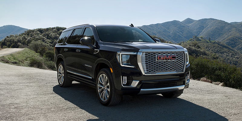 Black 2024 GMC Yukon on rugged hillside terrain