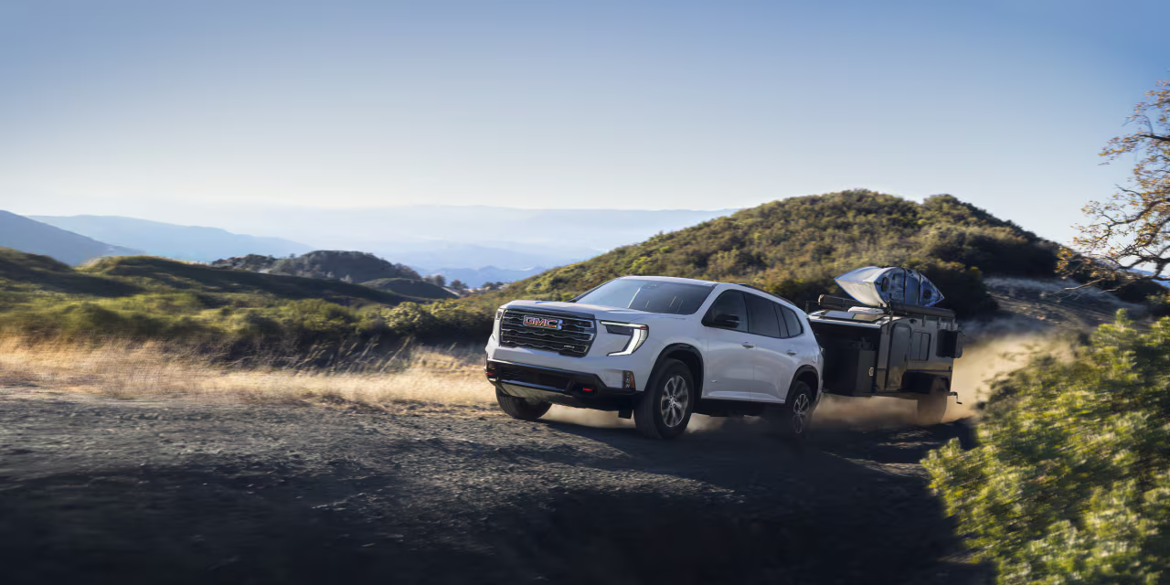2025 GMC Acadia towing trailer on a rugged mountain trail near Anderson Buick GMC of Abingdon.