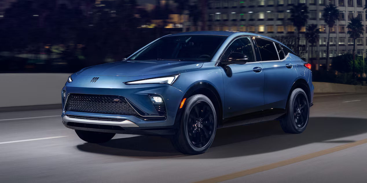 Blue Buick Envista driving at night in the city.