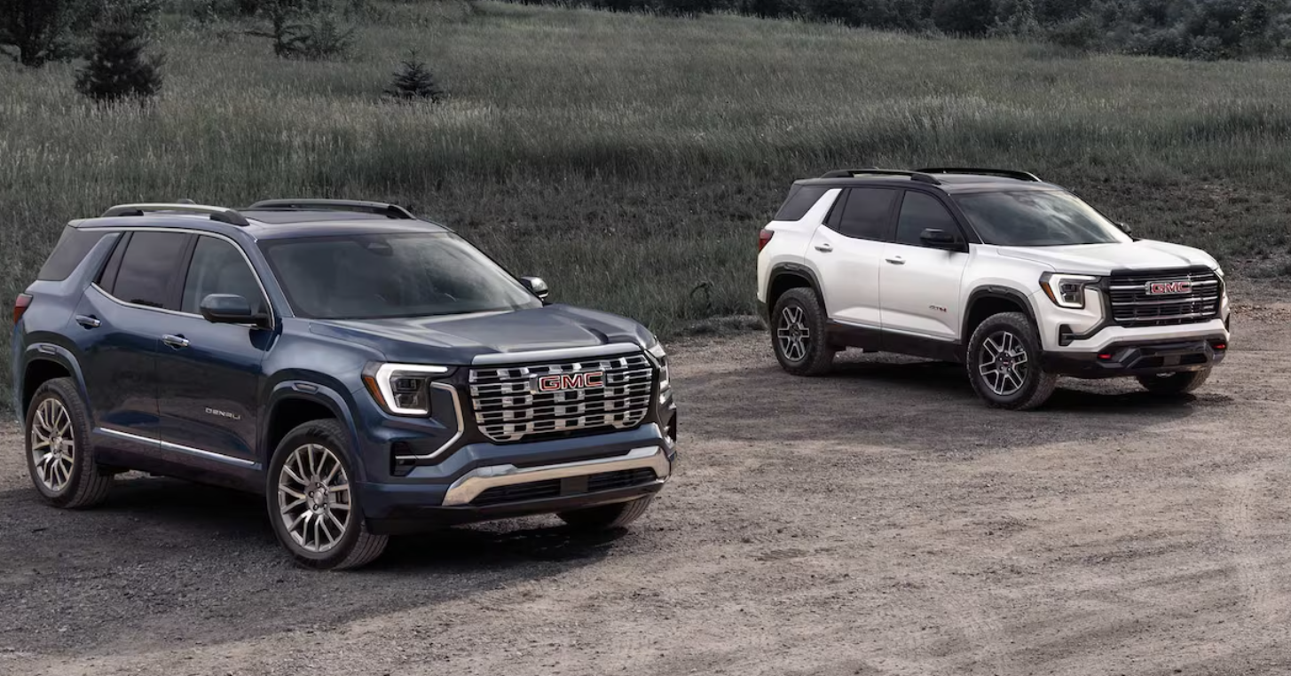Blue GMC Terrain Denali and white GMC Terrain AT4 SUVs parked outdoors on a dirt road near Anderson of Abingdon.