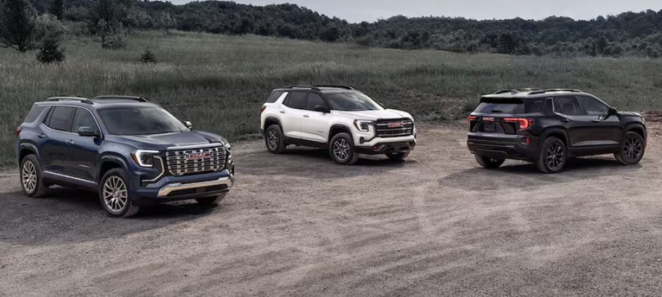 The 2026 GMC Terrain in three trims: Elevation, AT4, and Denali parked on grassy hill.