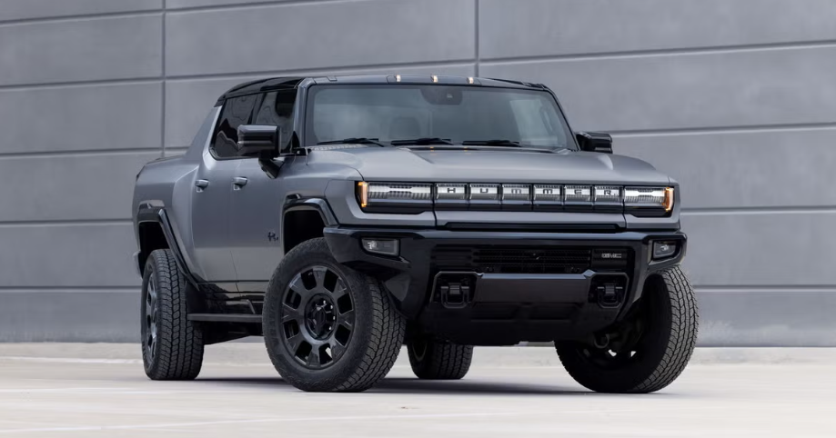 Grey 2026 hummer EV Pickup parked by building.